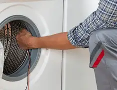 Dryer repair technician diagnosing and servicing a clothes dryer in Colorado Springs, CO