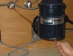 Garbage disposal repair technician tightening the mounting ring under a sink in Colorado Springs, CO