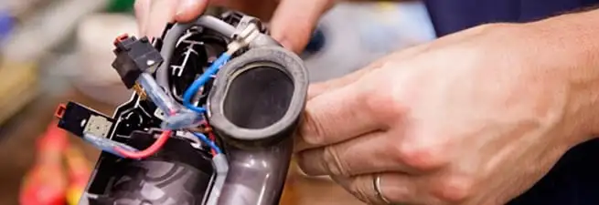 Vacuum repair technician reconnecting wiring and components in Colorado Springs, CO
