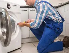 Washing machine repair technician servicing a front-load washer in Colorado Springs, CO