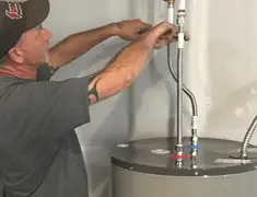 Water heater repair technician tightening supply line connections in Colorado Springs, CO